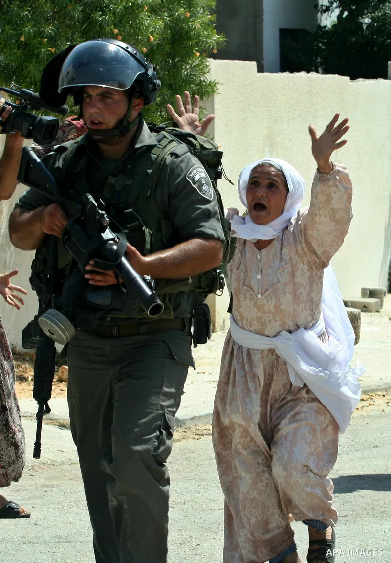 Palestinian woman attacks Israeli soldiers during clashes against the expropriation of Palestinian land by Israel in the village of Kafr Qaddum, near the West Bank city of Nablus on August 31, 2012. Photo by Nedal Eshtay...