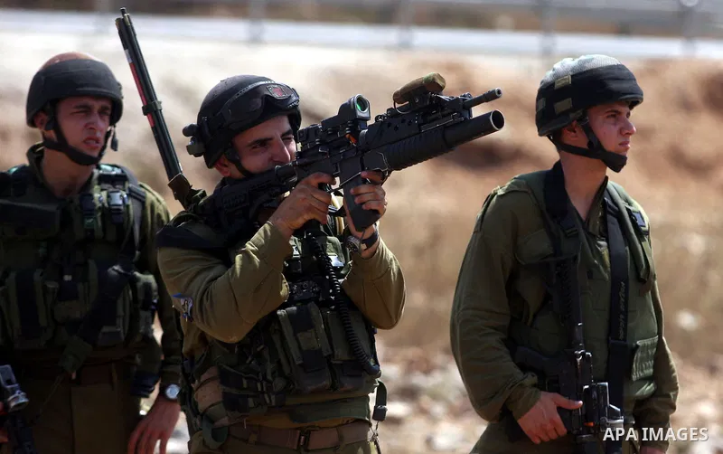 An Israeli soldier fires tear gas towards Palestinian demonstrators during clashes during a protest against the expansion of the nearby Jewish settlement of Halamish, in the West Bank village of Nabi Saleh, near Ramallah...
