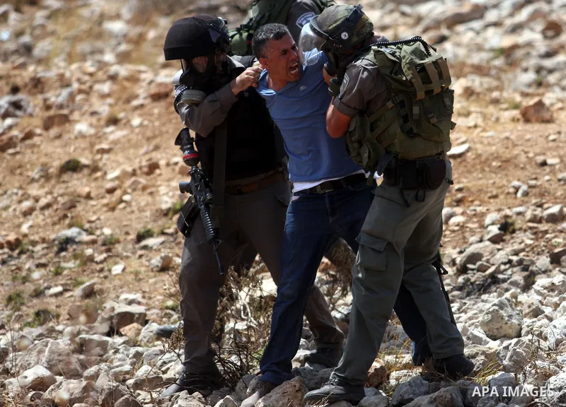 Israeli soldiers detain a demonstrator during clashes during a protest against the expansion of the nearby Jewish settlement of Halamish, in the West Bank village of Nabi Saleh, near Ramallah, Friday,August 31, 2012. Pho...