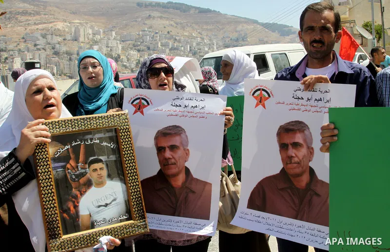 Palestinian children hold portraits of Palestinian prisoner Ibrahim Abu Hijleh, outside the Red Cross building in the West Bank city of Nablus on Sep. 01, 2012. as they protest against Israel's policy of administrative d...