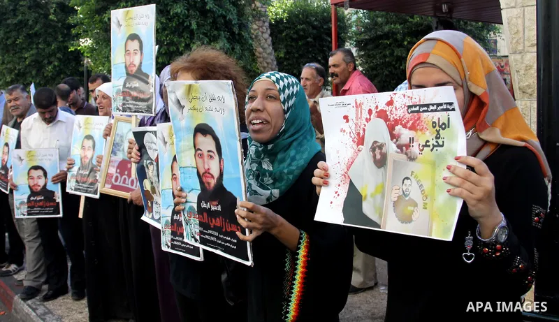 Palestinian protesters hold up banners and portraits of a prisoners jailed in Israel On hunger strike,during a rally in solidarity with prisoners in Israeli jails, in the West Bank city of Nablus on sep 1, 2012. Photo by...