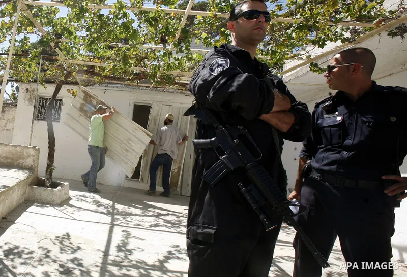 Israeli police stand guards while Israeli Jewish settlers work at a Palestinian house after Israeli police evict his owner in Ras al-Amoud neighborhood, south of al-Aqsa Mosque in Jerusalem's Old City, on 02 Septemper 20...