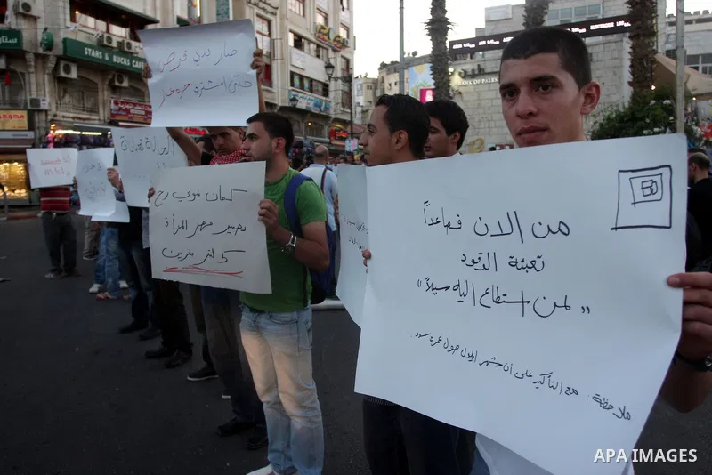 Palestinian protesters hold signs during a demonstration against the price rises, in the West Bank city of Ramallah, on September 02, 2012. Photo by Issam Rimawi