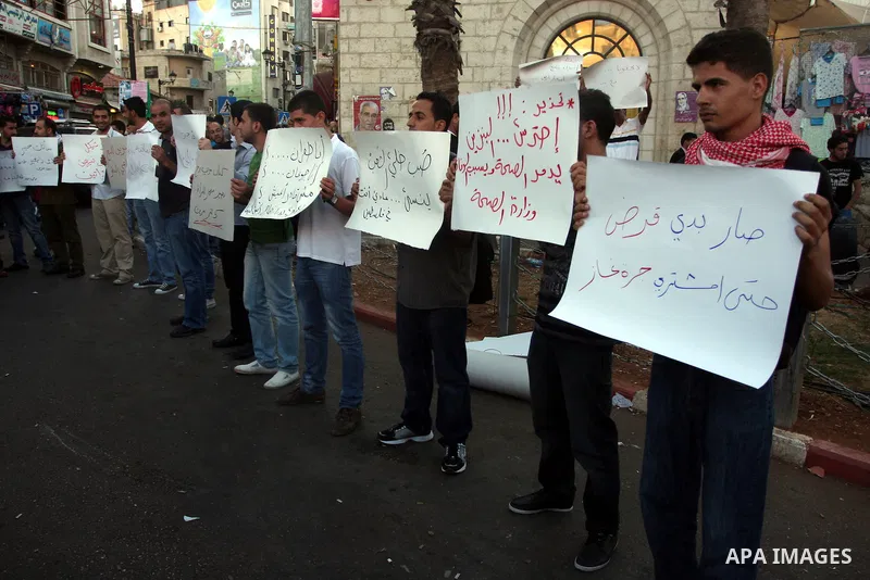 Palestinian protesters hold signs during a demonstration against the price rises, in the West Bank city of Ramallah, on September 02, 2012. Photo by Issam Rimawi