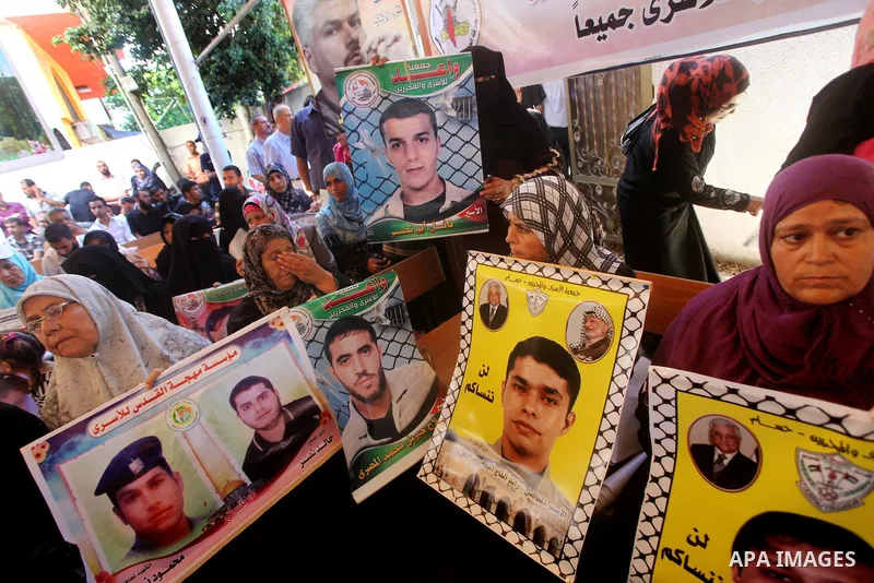 Palestinians hold a placard depicting jailed relatives during a protest in Gaza City calling for the release of Palestinian prisoners from Israeli jails September 3, 2012. Photo by Ashraf Amra