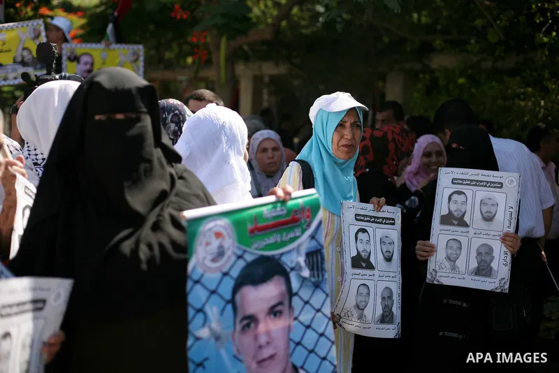 Palestinians hold a placard depicting jailed relatives during a protest in Gaza City calling for the release of Palestinian prisoners from Israeli jails September 3, 2012. Photo by Ashraf Amra