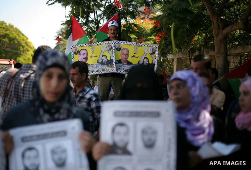 Palestinians hold a placard depicting jailed relatives during a protest in Gaza City calling for the release of Palestinian prisoners from Israeli jails September 3, 2012. Photo by Ashraf Amra