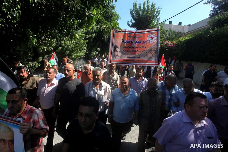 Palestinians hold a placard depicting jailed relatives during a protest in Gaza City calling for the release of Palestinian prisoners from Israeli jails September 3, 2012. Photo by Ashraf Amra