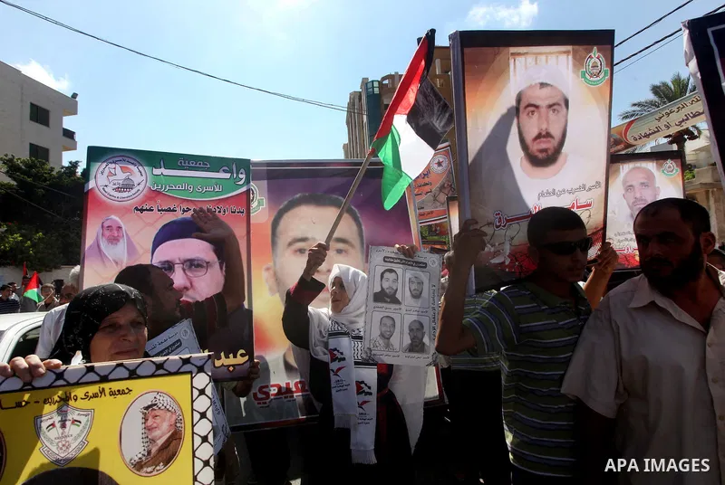 Palestinians hold a placard depicting jailed relatives during a protest in Gaza City calling for the release of Palestinian prisoners from Israeli jails September 3, 2012. Photo by Ashraf Amra