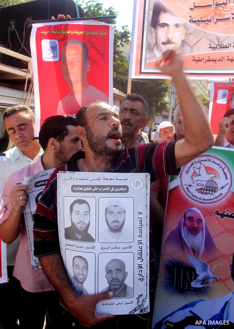 Palestinians hold a placard depicting jailed relatives during a protest in Gaza City calling for the release of Palestinian prisoners from Israeli jails September 3, 2012. Photo by Ashraf Amra