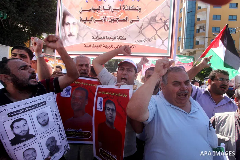 Palestinians hold a placard depicting jailed relatives during a protest in Gaza City calling for the release of Palestinian prisoners from Israeli jails September 3, 2012. Photo by Ashraf Amra