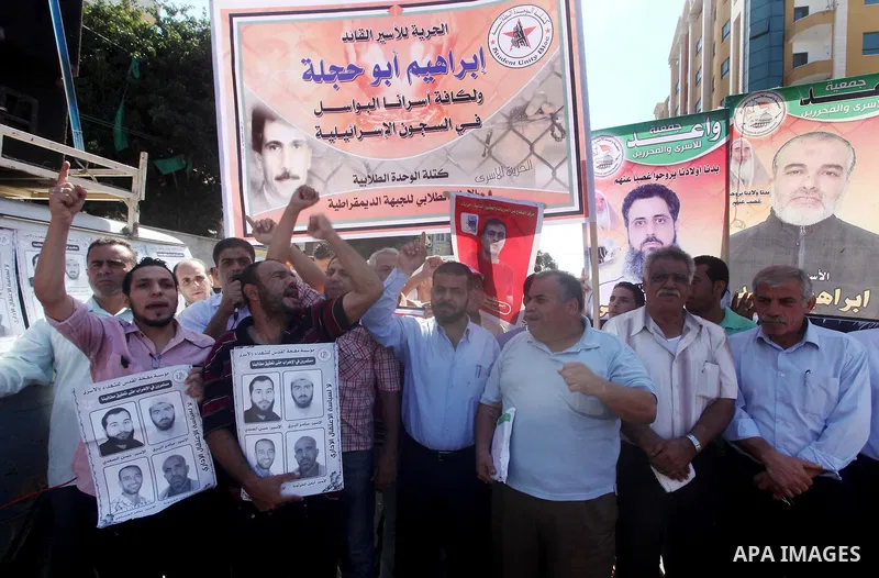 Palestinians hold a placard depicting jailed relatives during a protest in Gaza City calling for the release of Palestinian prisoners from Israeli jails September 3, 2012. Photo by Ashraf Amra