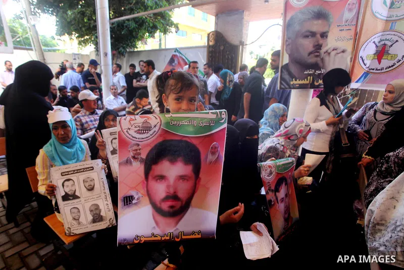 Palestinians hold a placard depicting jailed relatives during a protest in Gaza City calling for the release of Palestinian prisoners from Israeli jails September 3, 2012. Photo by Ashraf Amra