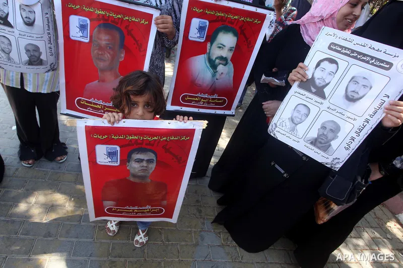 Palestinians hold a placard depicting jailed relatives during a protest in Gaza City calling for the release of Palestinian prisoners from Israeli jails September 3, 2012. Photo by Ashraf Amra