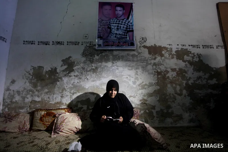 Palestinian Nadia Abu Nada holds a picture of her son Ihab Abu Nada at her home in the Shati refugee camp in Gaza City, Monday, Sept. 4, 2012. The death of a young Gaza man who set himself on fire because he could not fi...
