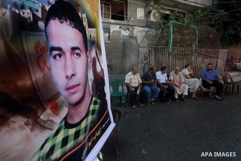Palestinians sit in the mourning tent of Ihab Abu Nada in the Shati refugee camp in Gaza City, Monday, Sept. 3, 2012. The death of a young Gaza man who set himself on fire because he could not find a job has sent shockwa...