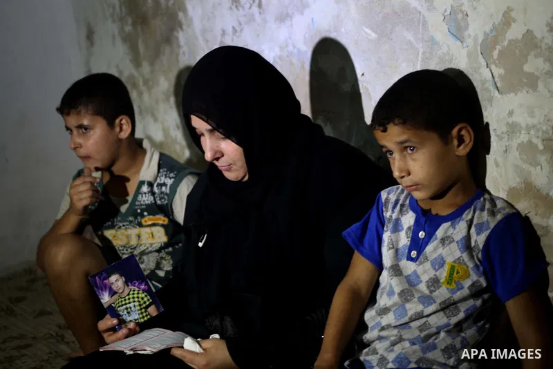 Palestinian Nadia Abu Nada holds a picture of her son Ihab Abu Nada at her home in the Shati refugee camp in Gaza City, Monday, Sept. 3, 2012. The death of a young Gaza man who set himself on fire because he could not fi...