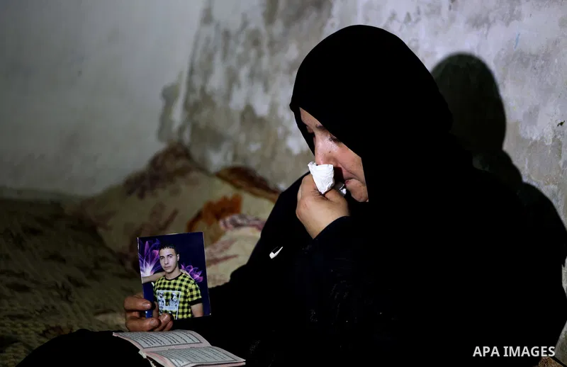 Palestinian Nadia Abu Nada holds a picture of her son Ihab Abu Nada at her home in the Shati refugee camp in Gaza City, Monday, Sept. 3, 2012. The death of a young Gaza man who set himself on fire because he could not fi...