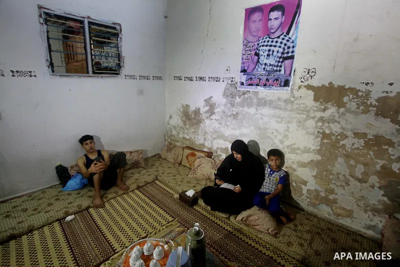 Palestinian Nadia Abu Nada holds a picture of her son Ihab Abu Nada at her home in the Shati refugee camp in Gaza City, Monday, Sept. 3, 2012. The death of a young Gaza man who set himself on fire because he could not fi...