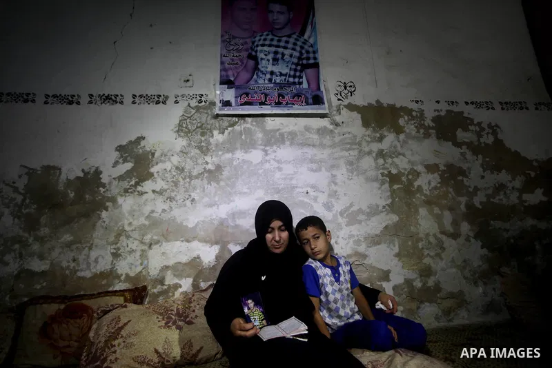 Palestinian Nadia Abu Nada holds a picture of her son Ihab Abu Nada at her home in the Shati refugee camp in Gaza City, Monday, Sept. 3, 2012. The death of a young Gaza man who set himself on fire because he could not fi...