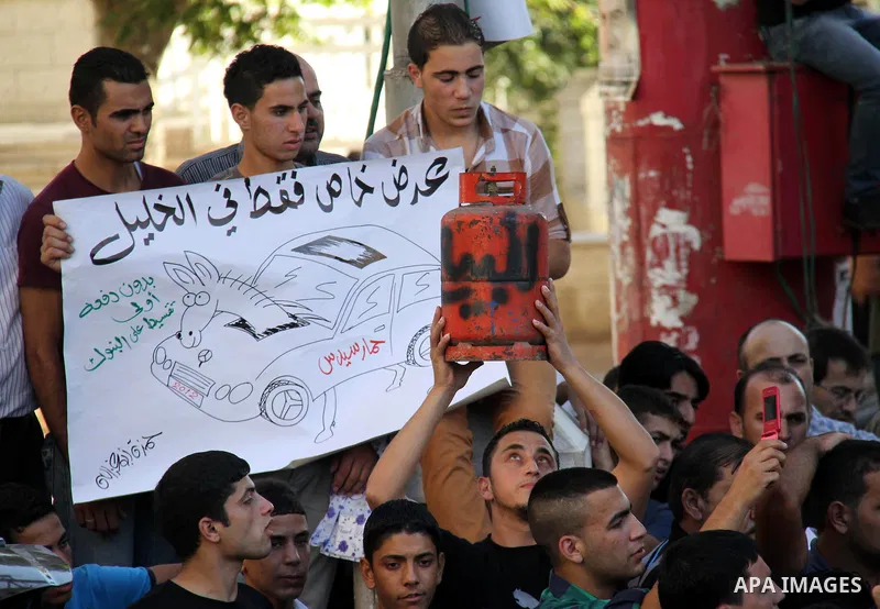 Palestinian protesters wear Guy Fawkes masks as they hold an effigy of Palestinian Prime Minister Salam Fayyad during a protest against the high cost of living, in the West Bank city of Hebron September 4, 2012. The Arab...