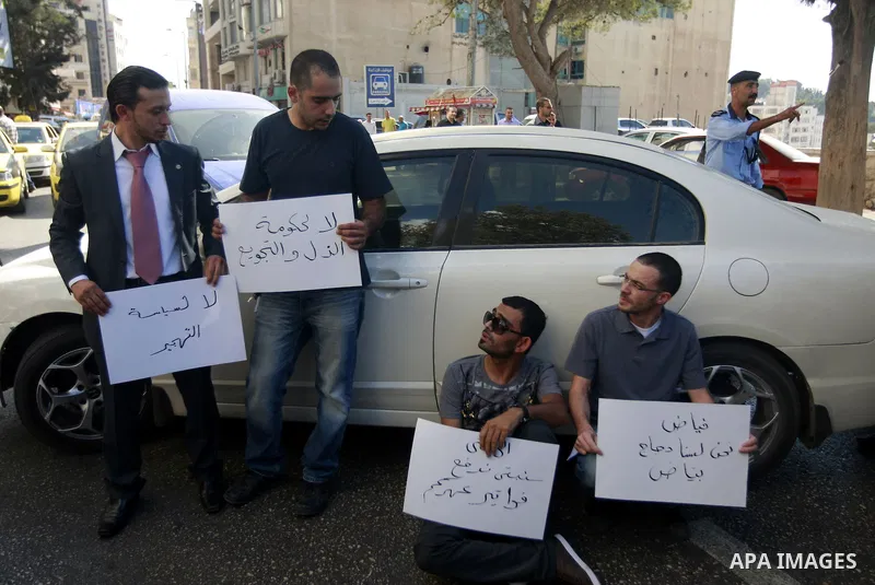 Palestinians hold placards against prime minister Salam Fayyad during a protest against the hight cost of living in the West Bank city of Ramallah on September 4, 2012. Photo by Issam Rimawi