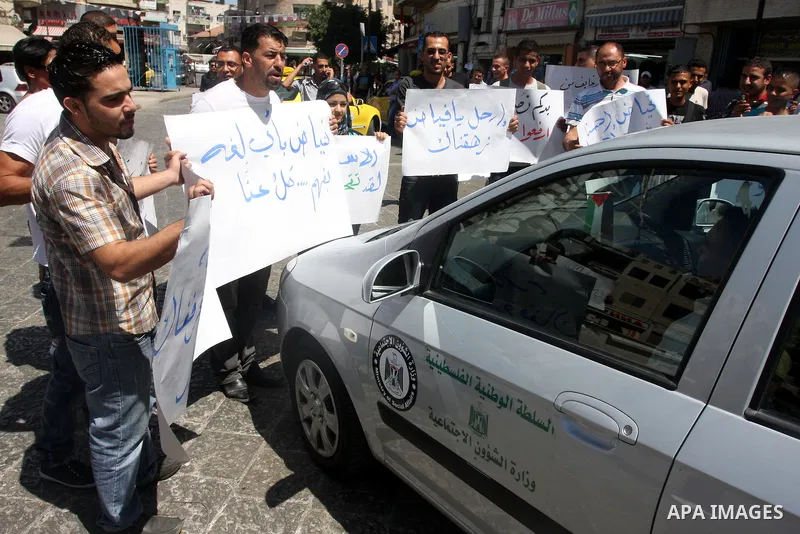 Palestinians hold placards against prime minister Salam Fayyad during a protest against the hight cost of living in the West Bank city of Ramallah on September 5, 2012. Photo by Issam Rimawi