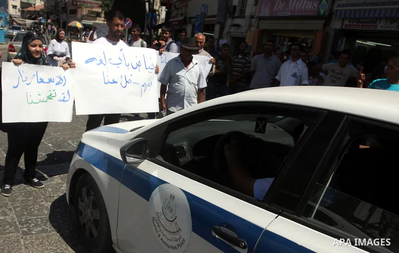 Palestinians hold placards against prime minister Salam Fayyad during a protest against the hight cost of living in the West Bank city of Ramallah on September 5, 2012. Photo by Issam Rimawi
