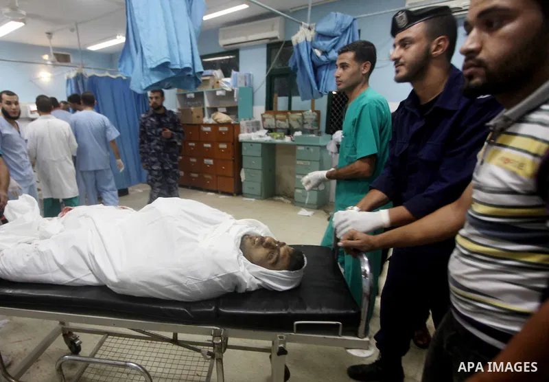 Palestinians stand by the body of one of three Palestinian militants killed in an Israeli airstrike earlier on September 5, 2012, at the morgue of the al-Aqsa hospital in Deir al-Balah, Gaza strip center. Photo by Ashraf...
