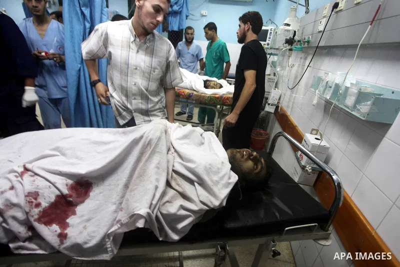 Palestinians stand by the body of one of three Palestinian militants killed in an Israeli airstrike earlier on September 5, 2012, at the morgue of the al-Aqsa hospital in Deir al-Balah, Gaza strip center. Photo by Ashraf...
