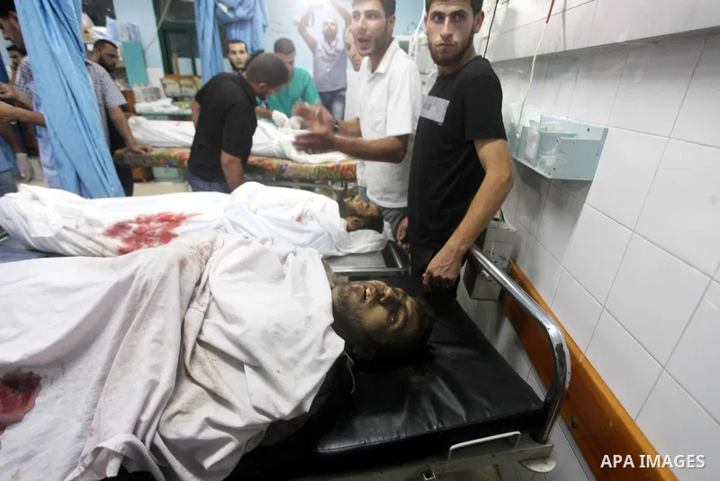 Palestinians gesture next to bodies of gunmen at a hospital in central Gaza Strip September 5, 2012. An Israeli air strike on the Hamas-governed Gaza Strip killed three gunmen as they tried to launch short-range rockets...
