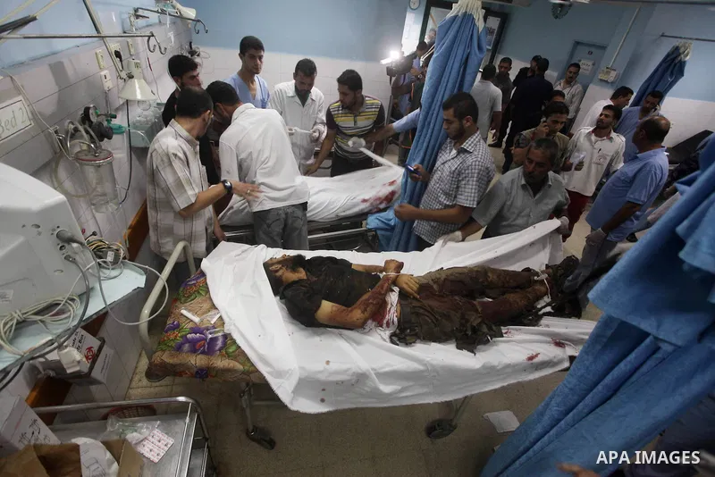 Palestinians gesture next to bodies of gunmen at a hospital in central Gaza Strip September 5, 2012. An Israeli air strike on the Hamas-governed Gaza Strip killed three gunmen as they tried to launch short-range rockets...