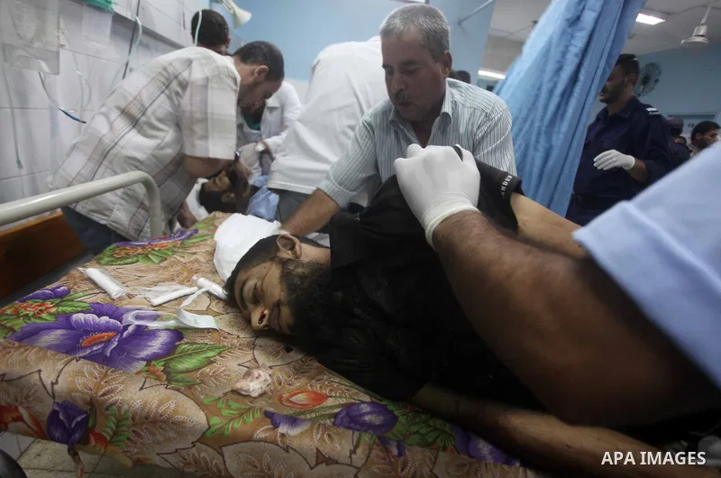 Palestinians gesture next to bodies of gunmen at a hospital in central Gaza Strip September 5, 2012. An Israeli air strike on the Hamas-governed Gaza Strip killed three gunmen as they tried to launch short-range rockets...