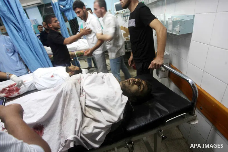 Palestinians gesture next to bodies of gunmen at a hospital in central Gaza Strip September 5, 2012. An Israeli air strike on the Hamas-governed Gaza Strip killed three gunmen as they tried to launch short-range rockets...