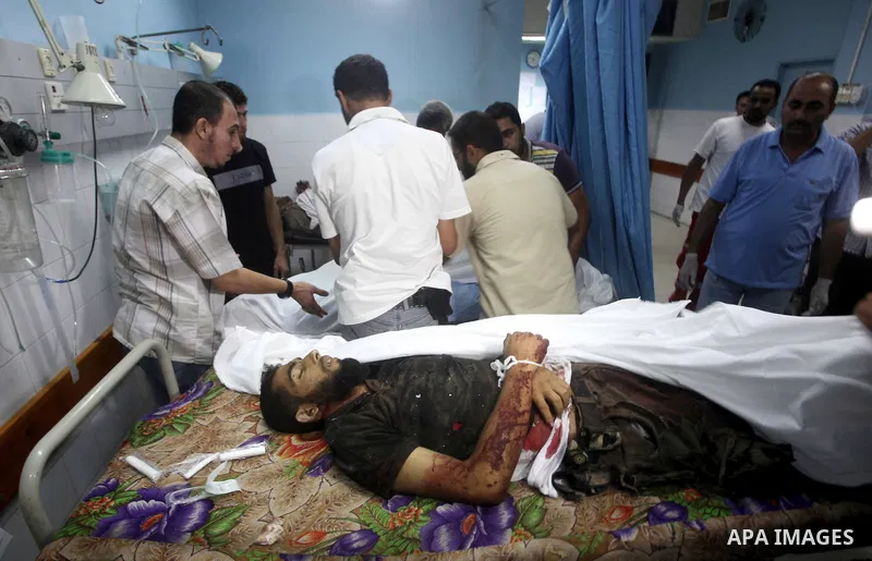 Palestinians gesture next to bodies of gunmen at a hospital in central Gaza Strip September 5, 2012. An Israeli air strike on the Hamas-governed Gaza Strip killed three gunmen as they tried to launch short-range rockets...