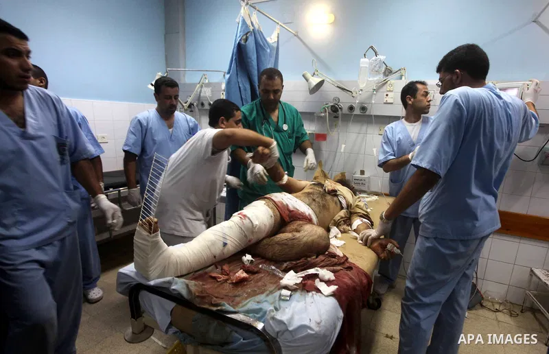 Palestinians gesture next to bodies of gunmen at a hospital in central Gaza Strip September 5, 2012. An Israeli air strike on the Hamas-governed Gaza Strip killed three gunmen as they tried to launch short-range rockets...