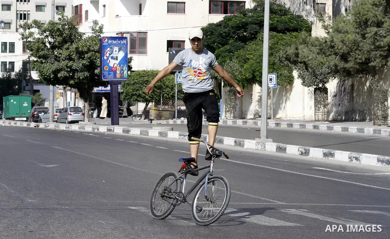 Palestinian youth ride a bicycle on a street in Gaza City, on Sep. 07, 2012. Photo by Majdi Fathi