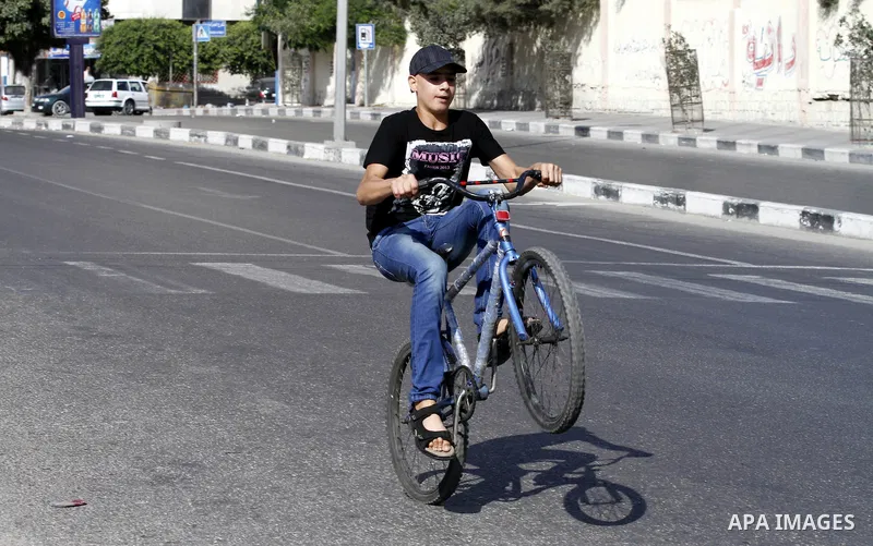 Palestinian youth ride a bicycle on a street in Gaza City, on Sep. 07, 2012. Photo by Majdi Fathi