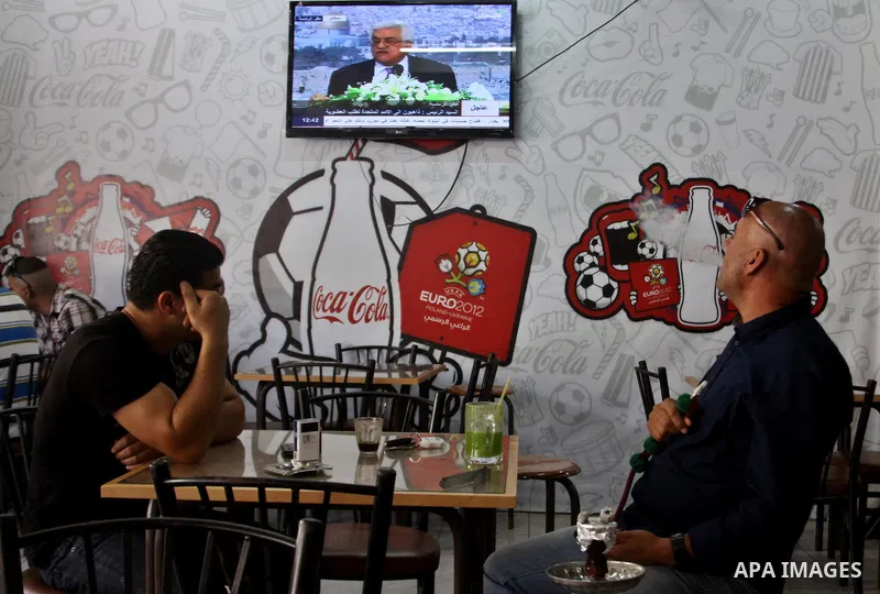 Palestinians watch TV as President Mahmoud Abbas (Abu Mazen), delivers speech to discusses the economic situation in the West Bank and Gaza strip, In a cafe in the West Bank city of Nablus on Sep. 08, 2012. Photo by Neda...