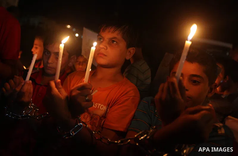 Palestinian children light candles during a rally in solidarity with prisoners in Israeli jails, in front of the Red Cross' offices in Gaza city, September 08, 2012. Photo by Majdi Fathi