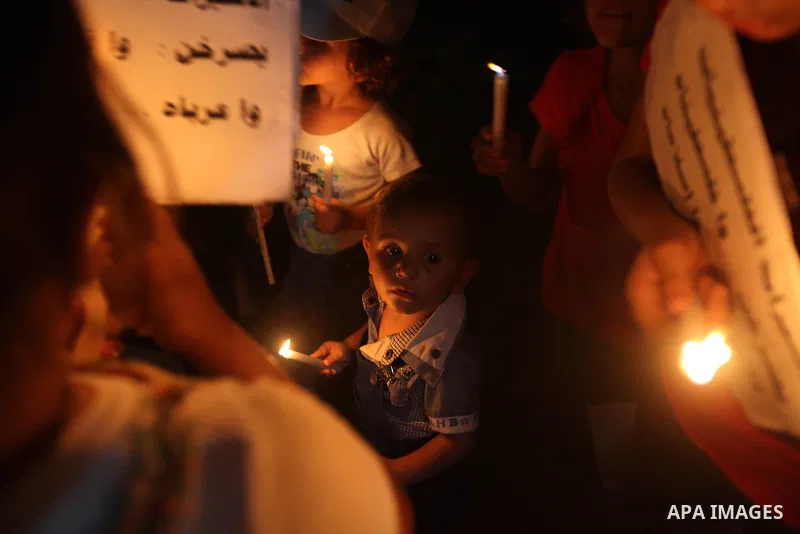 Palestinian children light candles during a rally in solidarity with prisoners in Israeli jails, in front of the Red Cross' offices in Gaza city, September 08, 2012. Photo by Majdi Fathi
