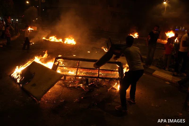 A Palestinian youth burns tyres during a protest against the high cost of living at Al-Amari refugee camp in the West Bank city of Ramallah on September 8, 2012. Dozens of Palestinians burned tyres and blocked the road i...