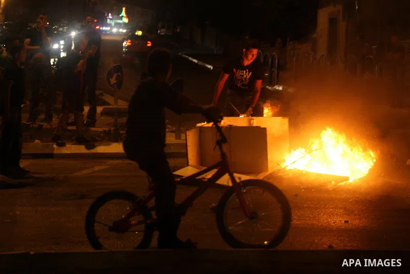 A Palestinian youth burns tyres during a protest against the high cost of living at Al-Amari refugee camp in the West Bank city of Ramallah on September 8, 2012. Dozens of Palestinians burned tyres and blocked the road i...