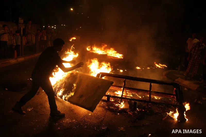 A Palestinian youth burns tyres during a protest against the high cost of living at Al-Amari refugee camp in the West Bank city of Ramallah on September 8, 2012. Dozens of Palestinians burned tyres and blocked the road i...