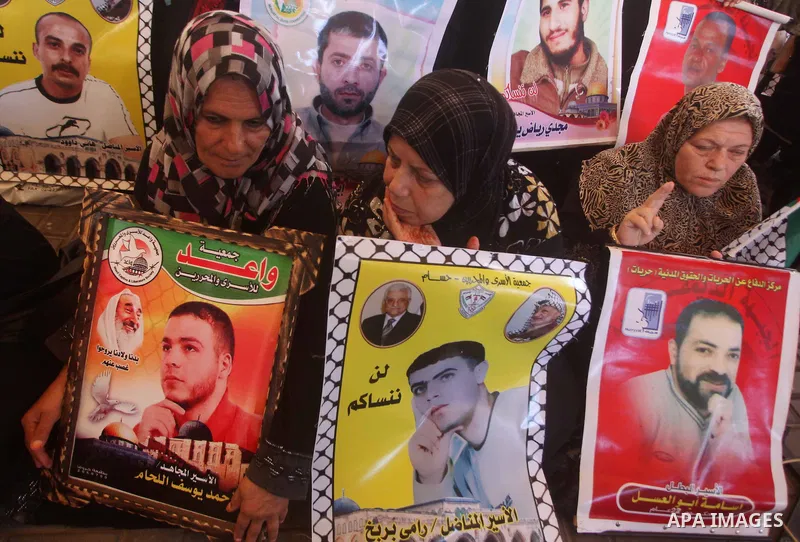 Palestinians hold a placard depicting jailed relatives during a protest in Gaza City calling for the release of Palestinian prisoners from Israeli jails September 10, 2012. Photo by Ashraf Amra