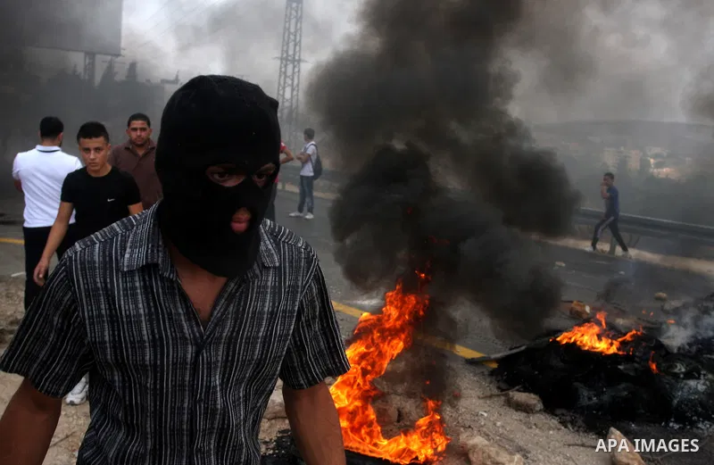 Palestinian youths close streets in Ramallah by burning tires during a protest against the high cost of living on September 10, 2012. Cities across the West Bank ground to a halt as transport unions called a mass general...