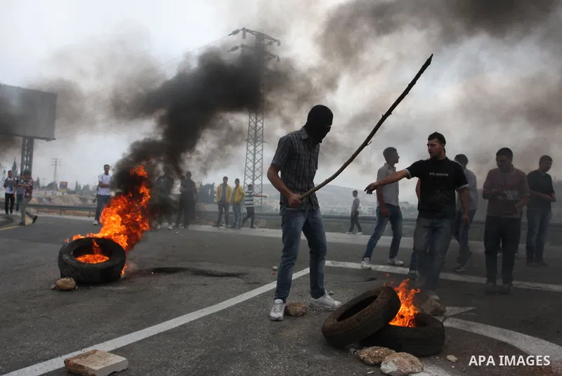 Palestinian youths close streets in Ramallah by burning tires during a protest against the high cost of living on September 10, 2012. Cities across the West Bank ground to a halt as transport unions called a mass general...
