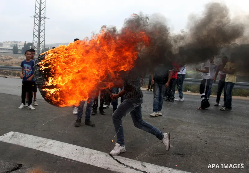 Palestinian youths close streets in Ramallah by burning tires during a protest against the high cost of living on September 10, 2012. Cities across the West Bank ground to a halt as transport unions called a mass general...