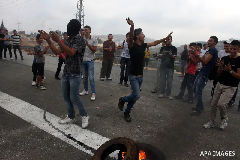 Palestinian youths close streets in Ramallah by burning tires during a protest against the high cost of living on September 10, 2012. Cities across the West Bank ground to a halt as transport unions called a mass general...
