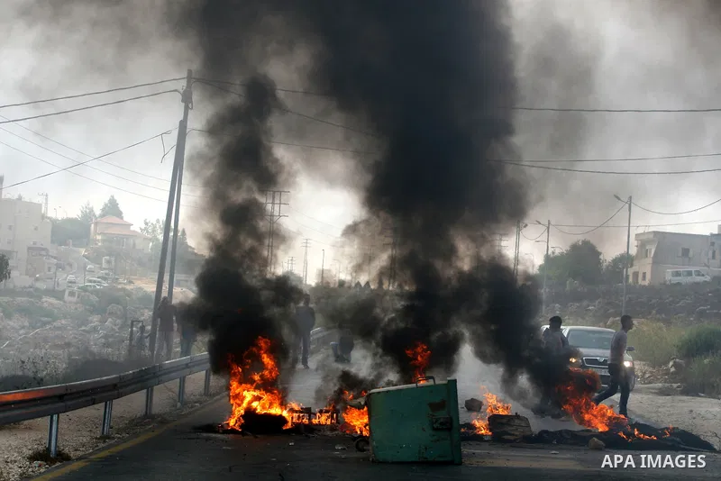 Palestinian youths close streets in Ramallah by burning tires during a protest against the high cost of living on September 10, 2012. Cities across the West Bank ground to a halt as transport unions called a mass general...